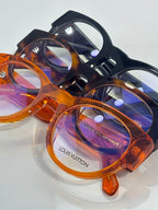 Round eyeglasses in blue-black and orange tortoise frames, clear lenses