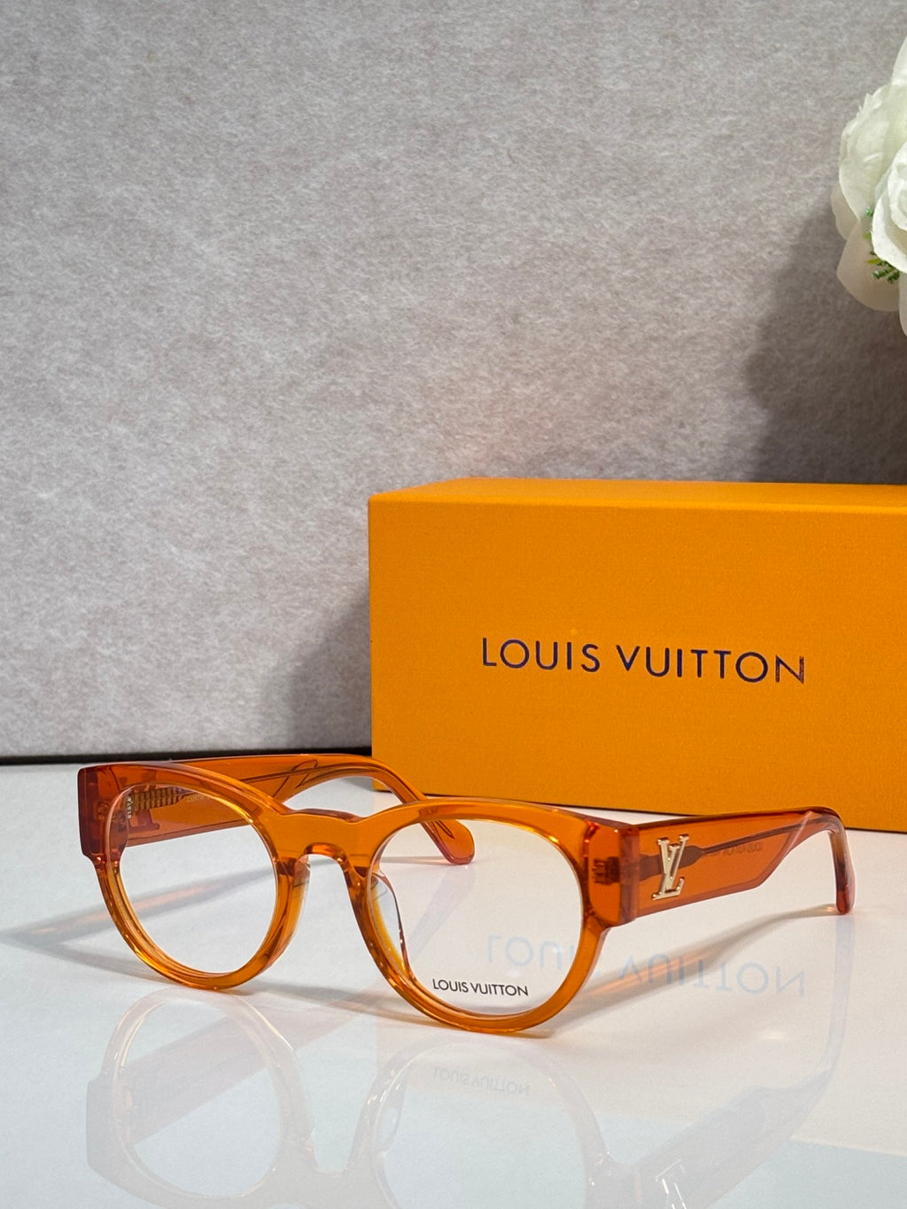 Orange tortoise eyeglasses with clear lenses and gold-toned temple logo