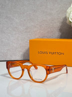 Orange tortoise eyeglasses with clear lenses and gold-toned temple logo