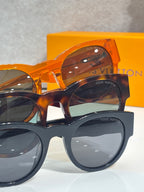 Sunglasses with orange tortoiseshell frames and dark lenses