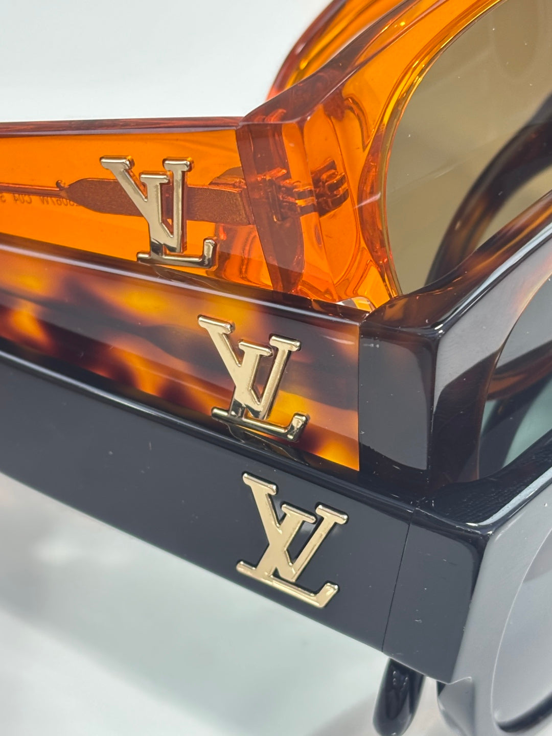 Sunglasses frame close-up with LV logo on orange and black arms