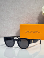 Sunglasses with black frames and dark lenses, rounded shape