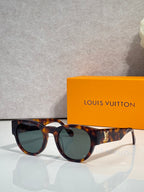 Sunglasses with dark tortoiseshell frames and greenish lenses