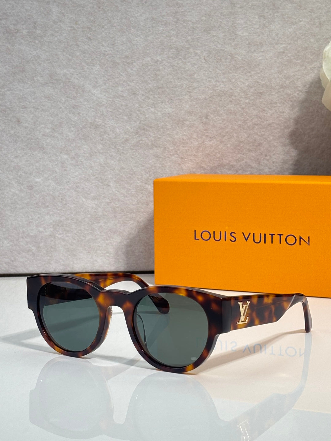 Sunglasses with dark tortoiseshell frames and greenish lenses