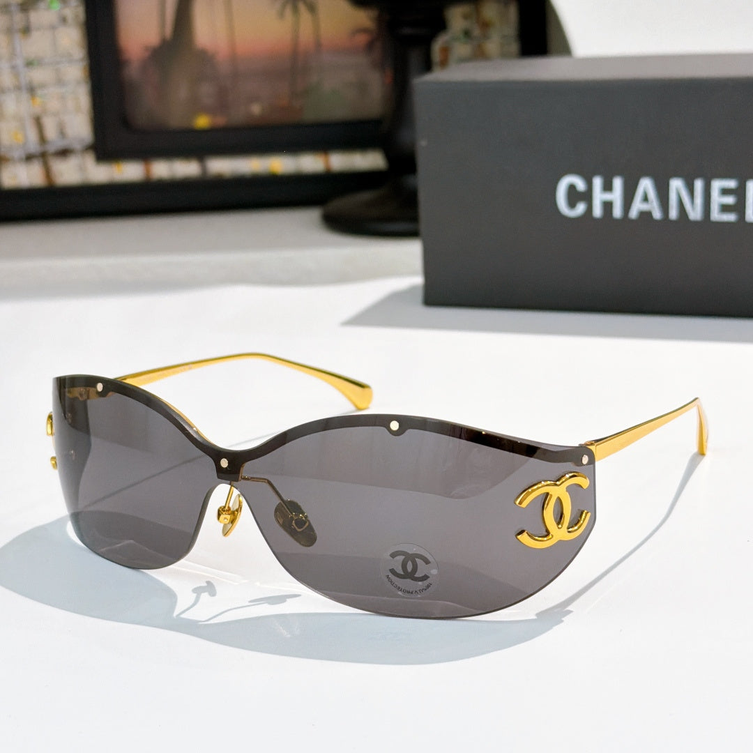 Black cat-eye sunglasses with dark gray tinted lenses and gold-tone logo hardware