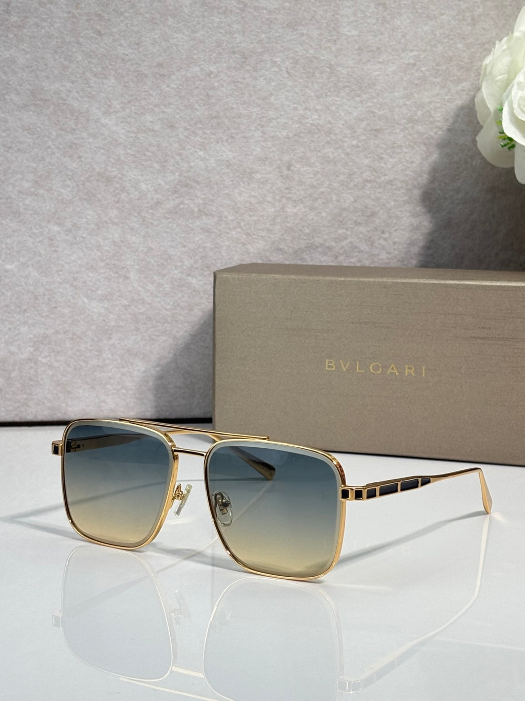 Bvlgari sunglasses with gold-tone frames and blue gradient tinted lenses