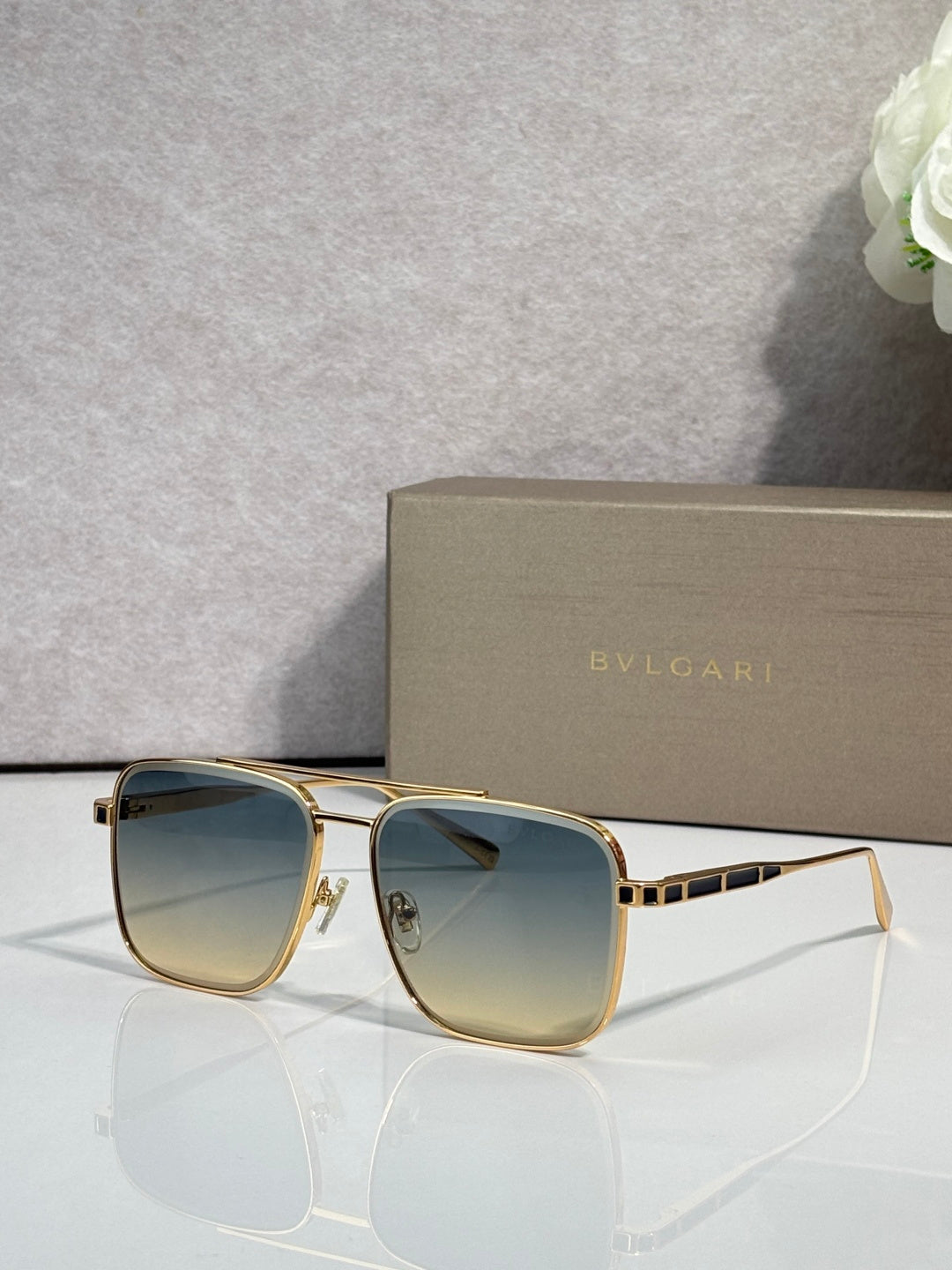 Bvlgari sunglasses with gold-tone frames and blue gradient tinted lenses