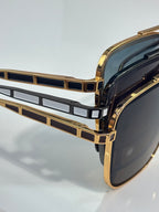 Gold-tone sunglasses close-up of geometric front detail with dark lenses
