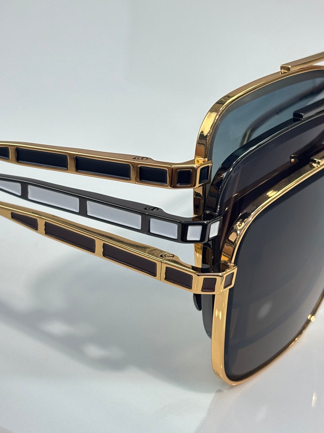 Gold-tone sunglasses close-up of geometric front detail with dark lenses