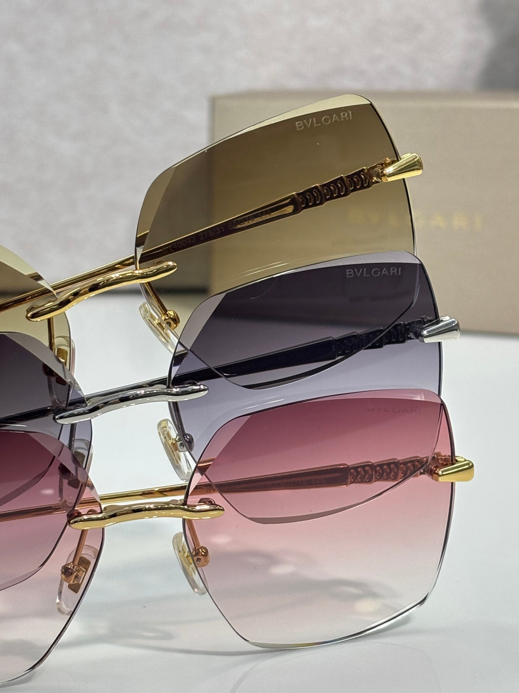 Gold sunglasses stacked view with tinted lenses and engraved top bar