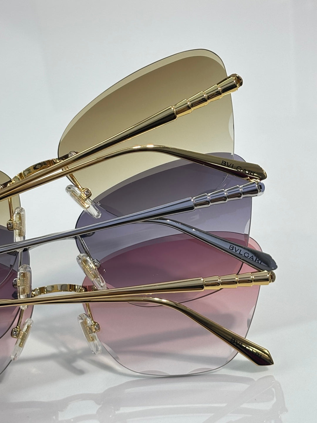 Bvlgari sunglasses side view, gold frame, purple gradient lenses, slim metal temples