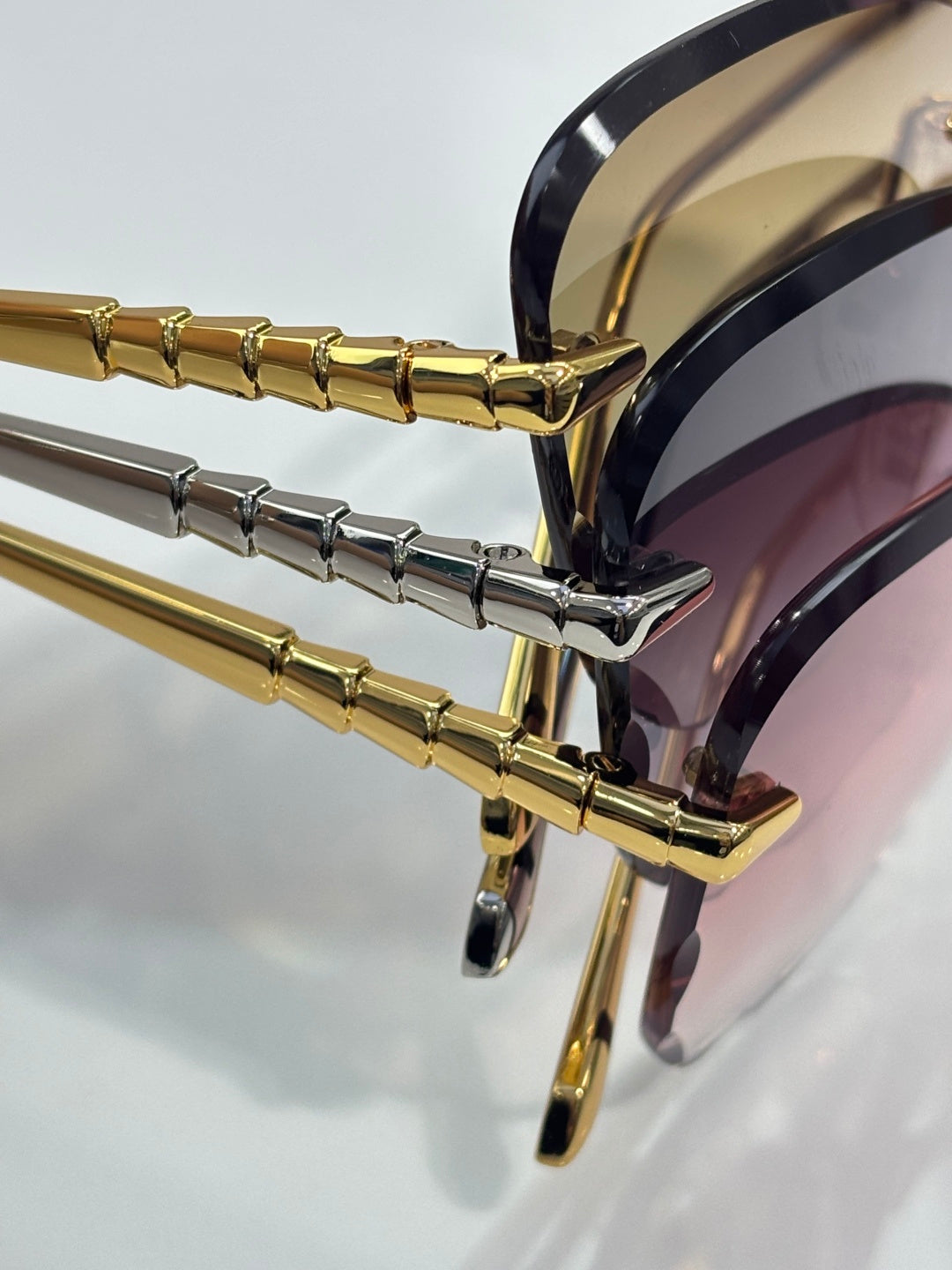 Bvlgari sunglasses temple detail, gold and silver bars on hinge with mirrored lenses