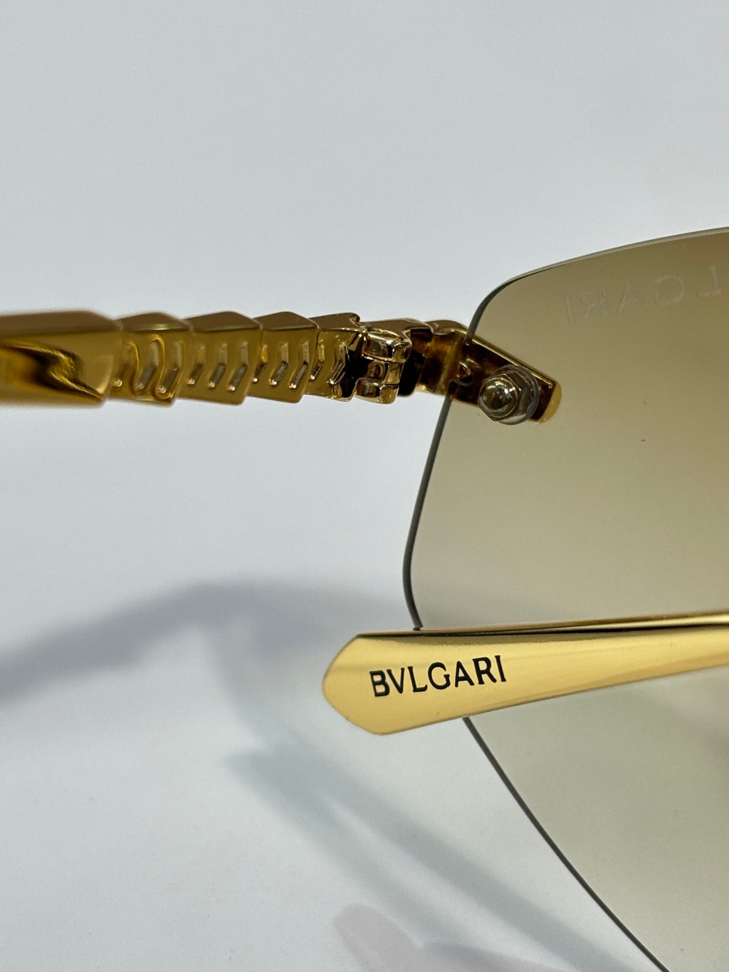 Bvlgari sunglasses close-up: gold ridged temple with BVLGARI engraving