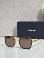 Chanel round sunglasses with dark lenses and gold-tone metal frame, temple logo
