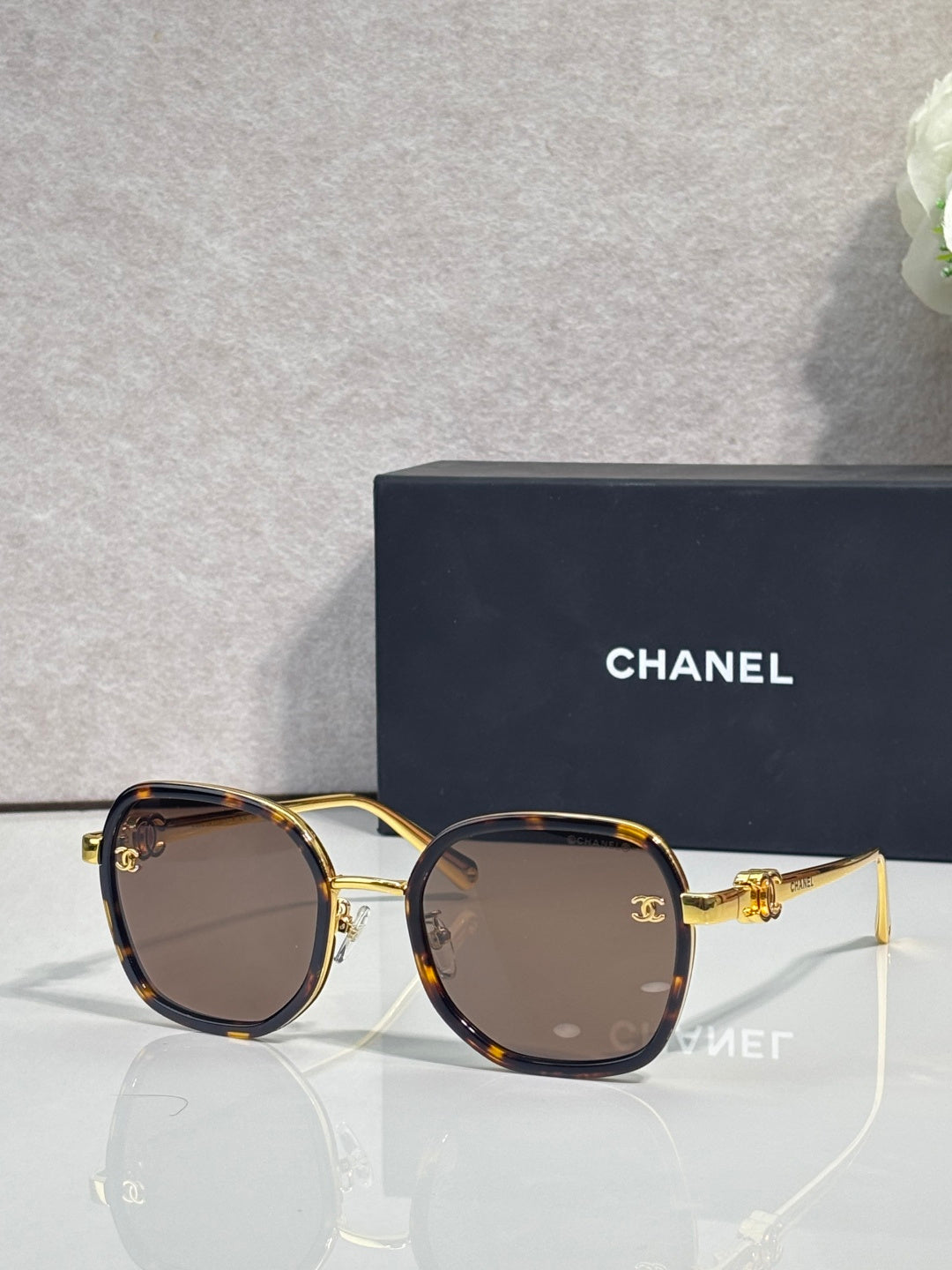 Chanel round sunglasses with dark lenses and gold-tone metal frame, temple logo