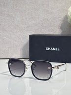 Chanel round sunglasses with dark lenses, navy frame and gold-tone metal accents