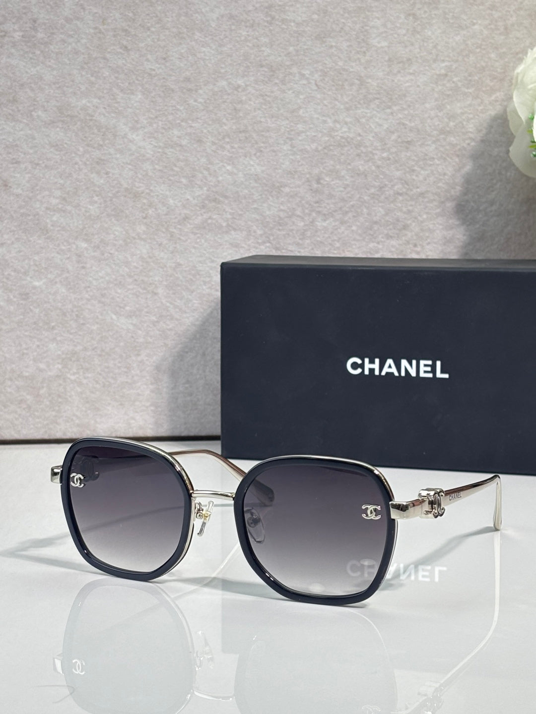 Chanel round sunglasses with dark lenses, navy frame and gold-tone metal accents
