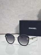 Round CHANEL sunglasses with dark lenses and blue-black metal frame