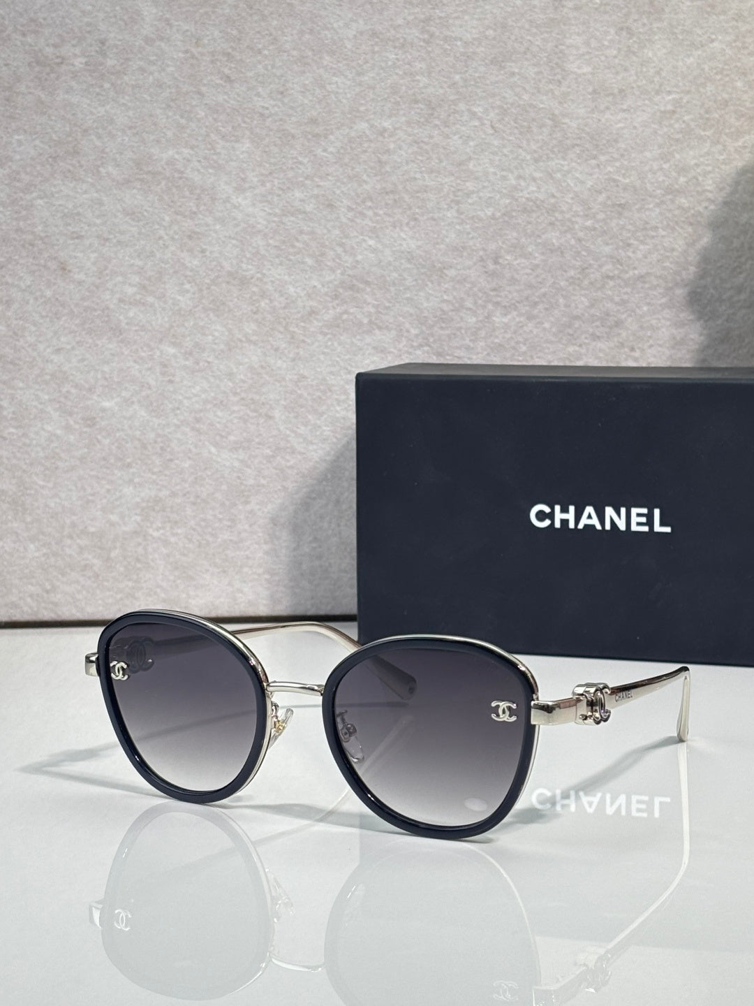 Round CHANEL sunglasses with dark lenses and blue-black metal frame
