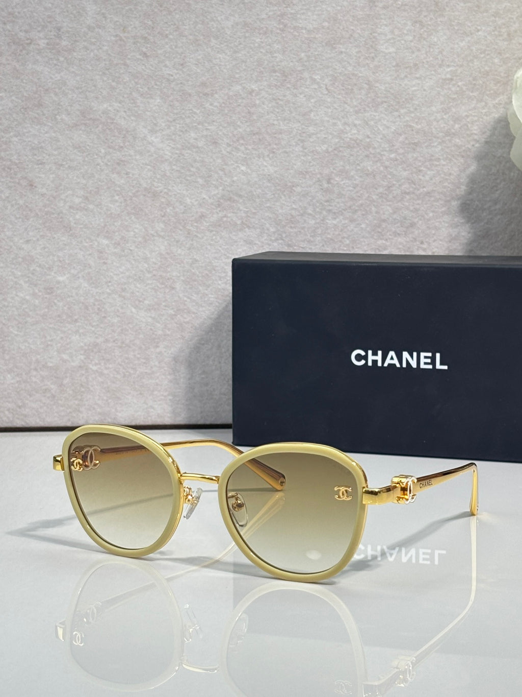 Round CHANEL sunglasses with light-tinted lenses and gold metal frame