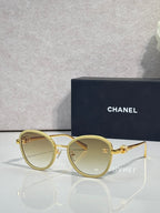 Round CHANEL sunglasses with light-tinted lenses and gold metal frame