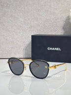 Round CHANEL sunglasses with dark-blue lenses and gold metal frame