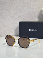 Round CHANEL sunglasses with dark lenses and tortoise-accented frame