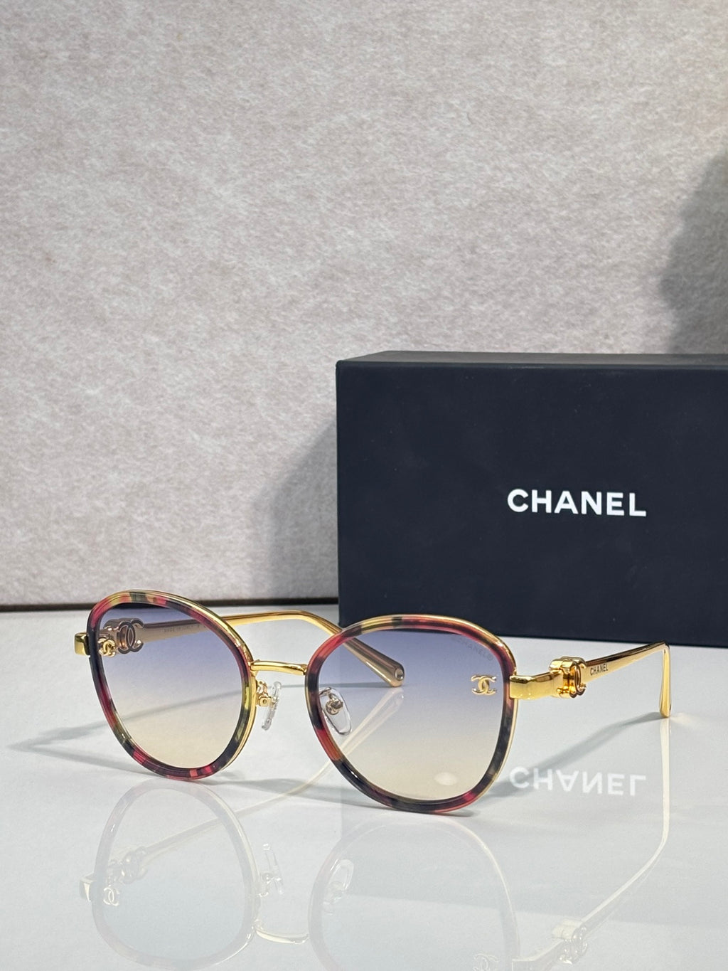 Round CHANEL sunglasses with smoky lenses and tortoise-red metal frame