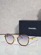 Round CHANEL sunglasses with smoky lenses and tortoise-red metal frame