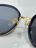 Close-up of CHANEL round sunglasses with dark lenses and gold rim