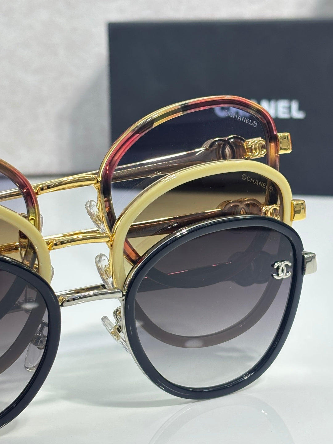 Close-up of CHANEL sunglasses with mixed dark and gold frames
