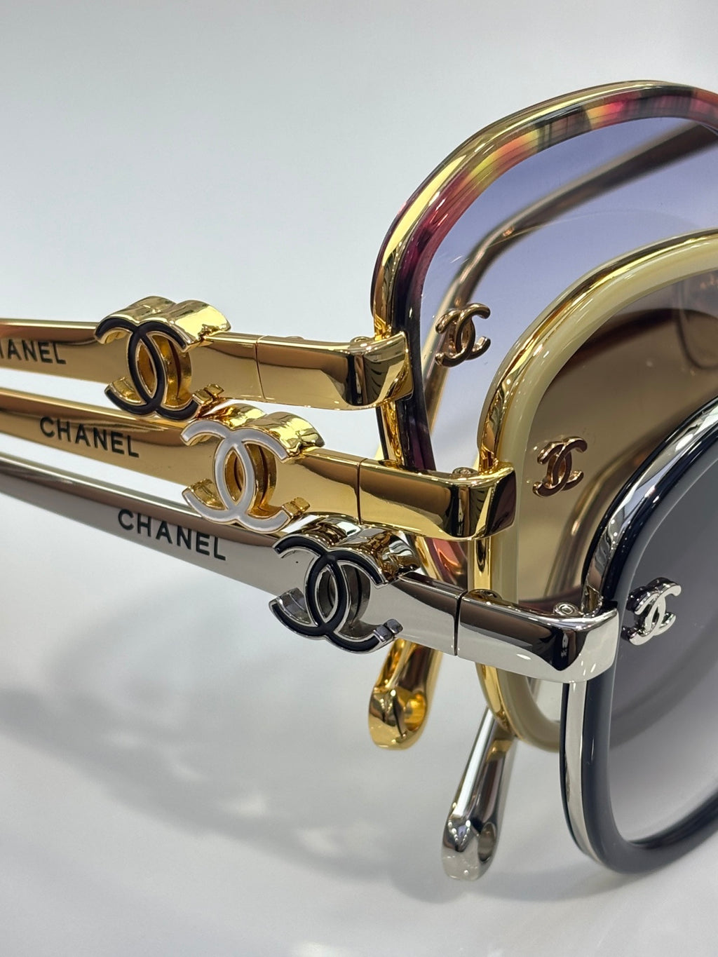 Close-up of CHANEL sunglasses with iridescent temple and gold hardware