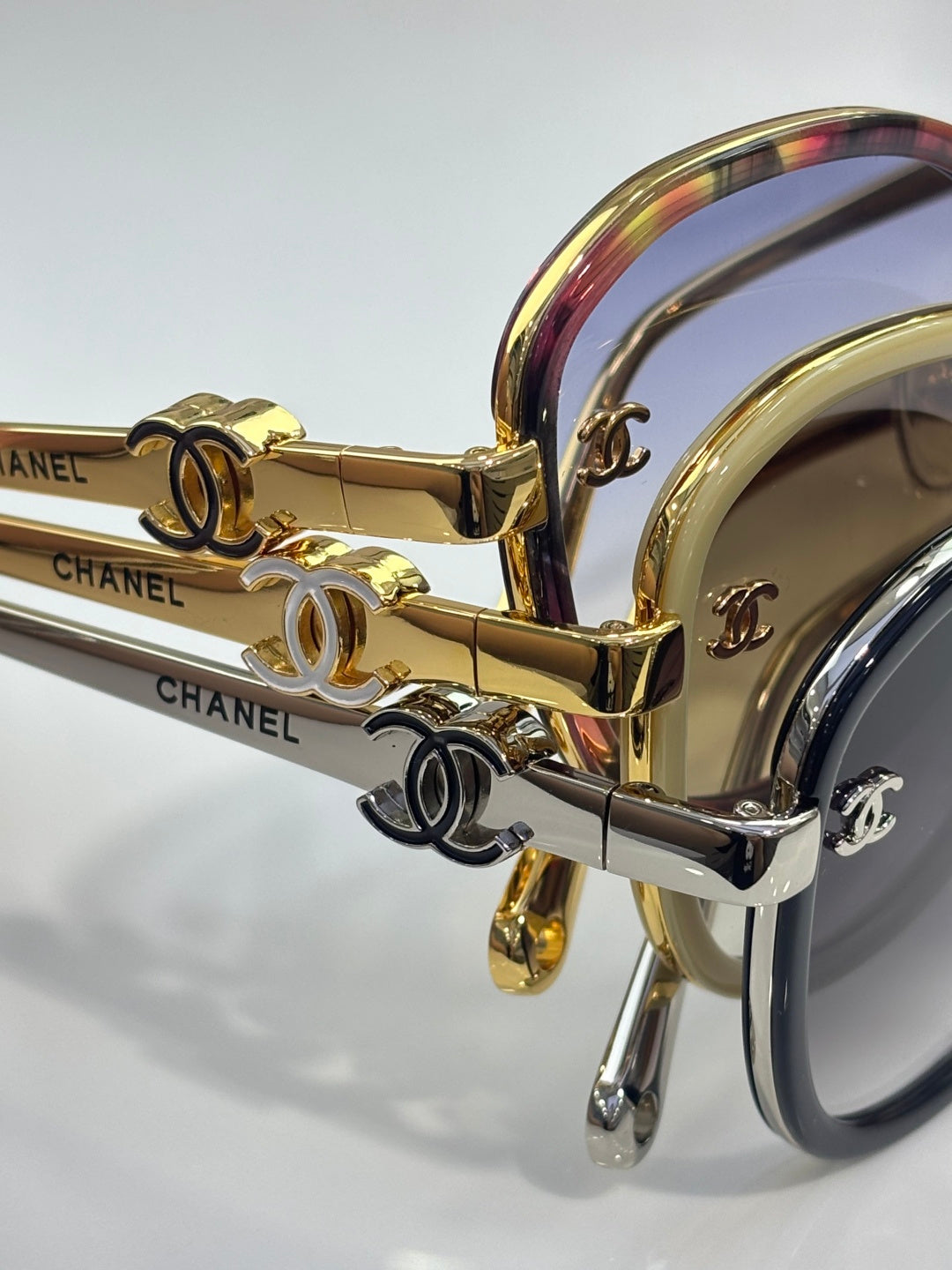Close-up of CHANEL sunglasses with iridescent temple and gold hardware