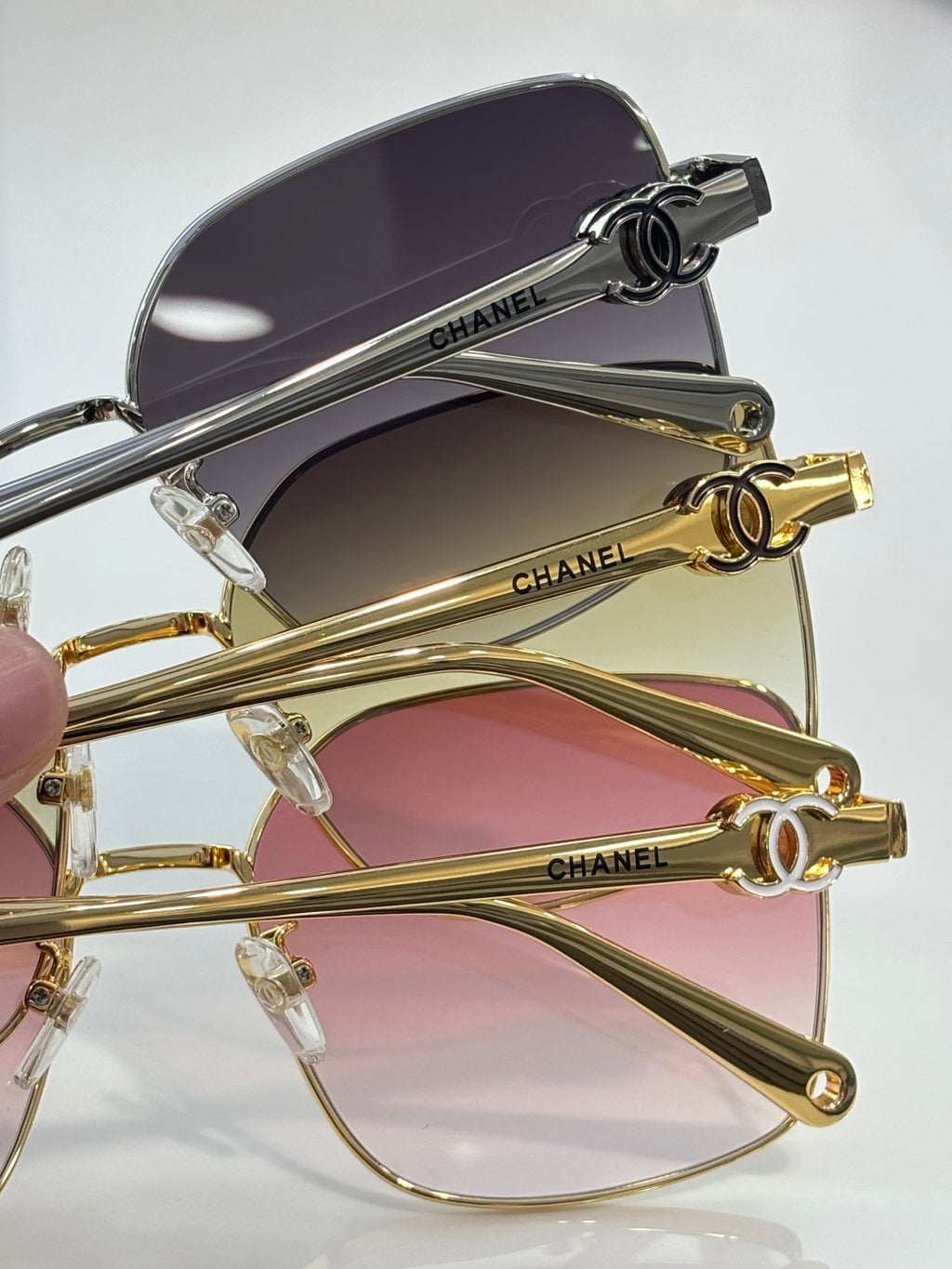 Gold-tone eyeglasses with purple-tinted lenses and black branded temple