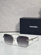 Silver-tone eyeglasses with dark lenses and thin metal frame with gold accents