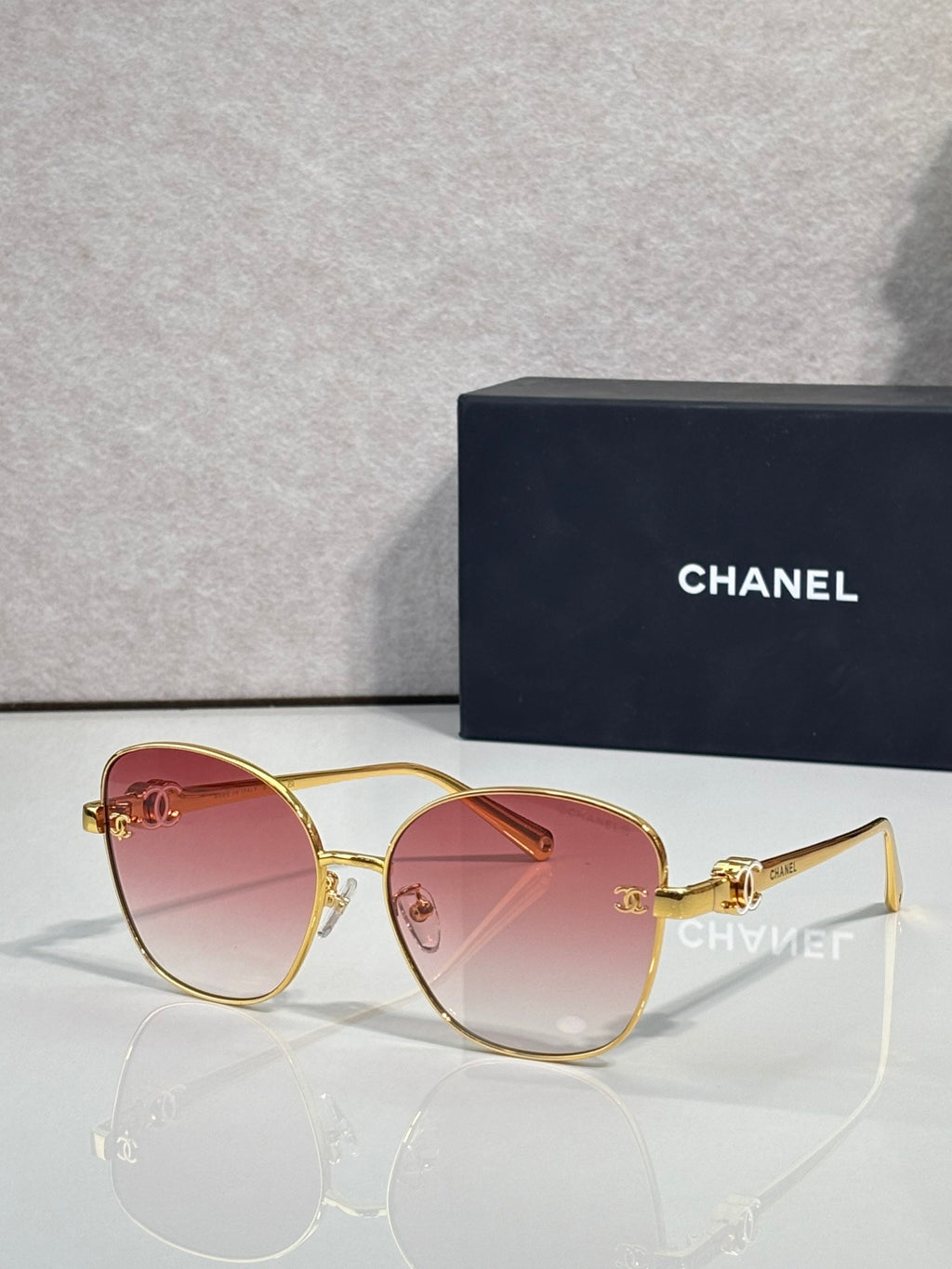Chanel sunglasses with gold cat-eye frames and pink tinted lenses