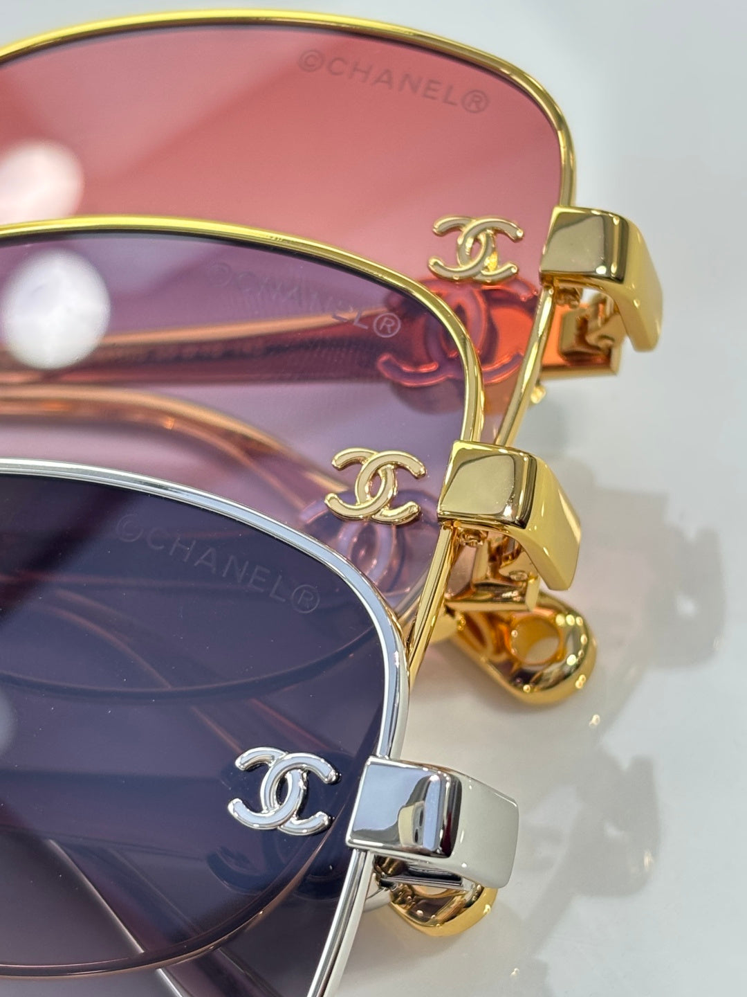 Chanel sunglasses close-up with gold frame and pink tinted lenses