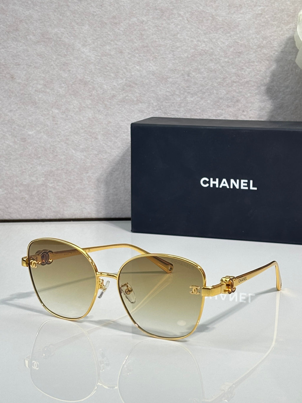 Chanel sunglasses with gold cat-eye frames and light amber tinted lenses