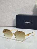 Chanel sunglasses with gold cat-eye frames and light amber tinted lenses