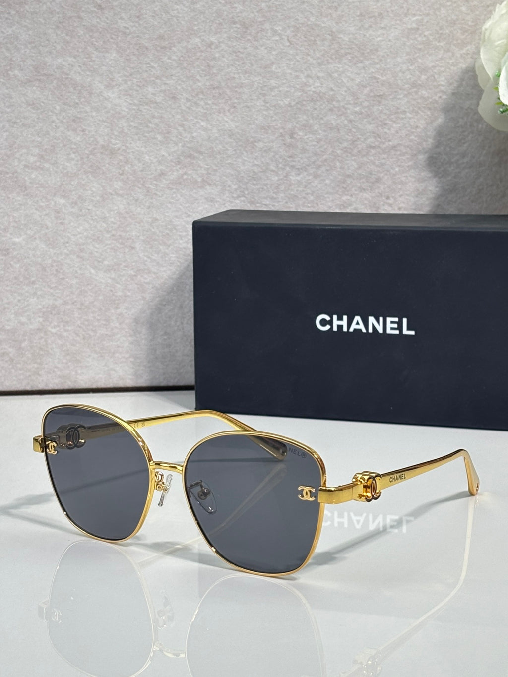 Chanel sunglasses with gold round cat-eye frames and dark brown gradient lenses