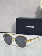 Chanel sunglasses with gold round cat-eye frames and dark brown gradient lenses