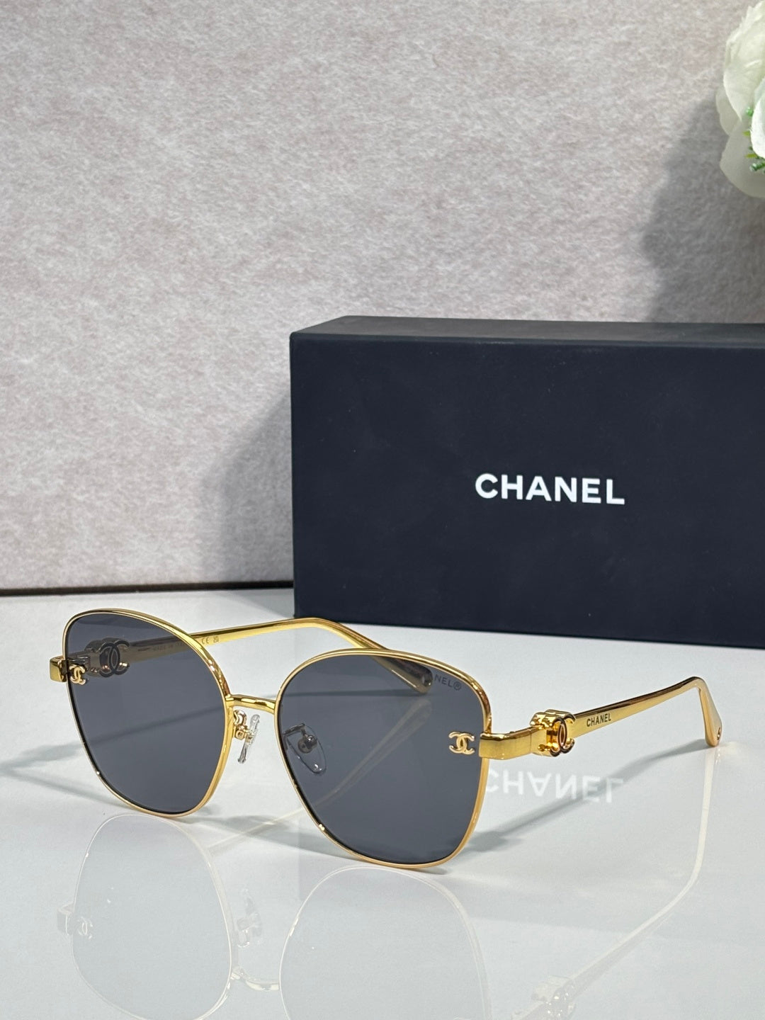 Chanel sunglasses with gold round cat-eye frames and dark brown gradient lenses