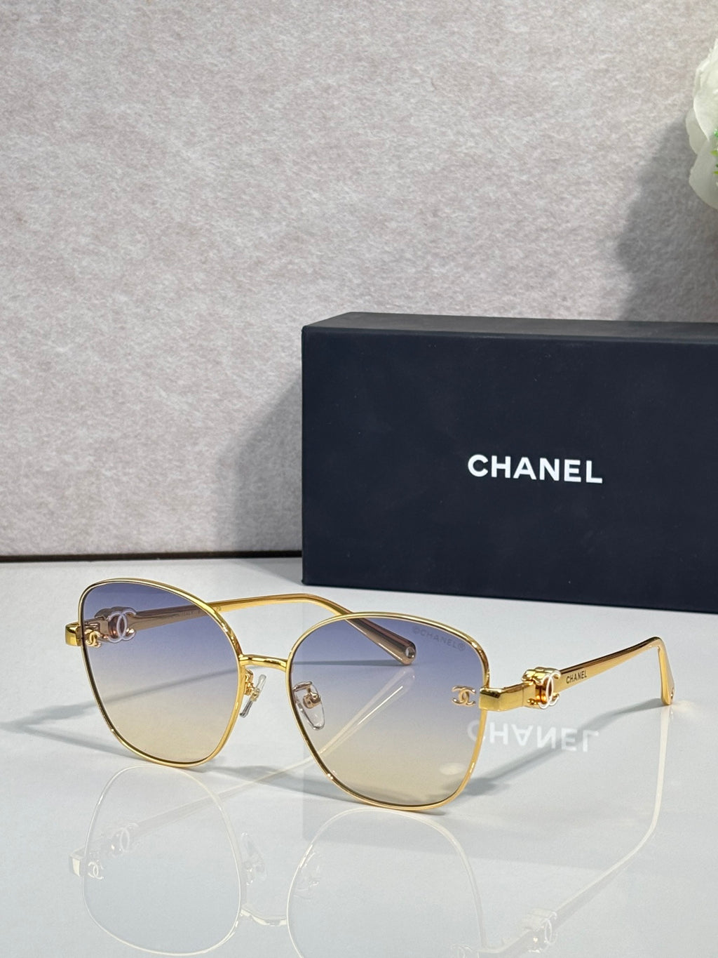 Chanel sunglasses with gold cat-eye frames and medium brown tinted lenses
