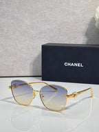 Chanel sunglasses with gold cat-eye frames and medium brown tinted lenses
