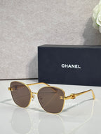 Chanel sunglasses with gold round cat-eye frames and dark brown tinted lenses