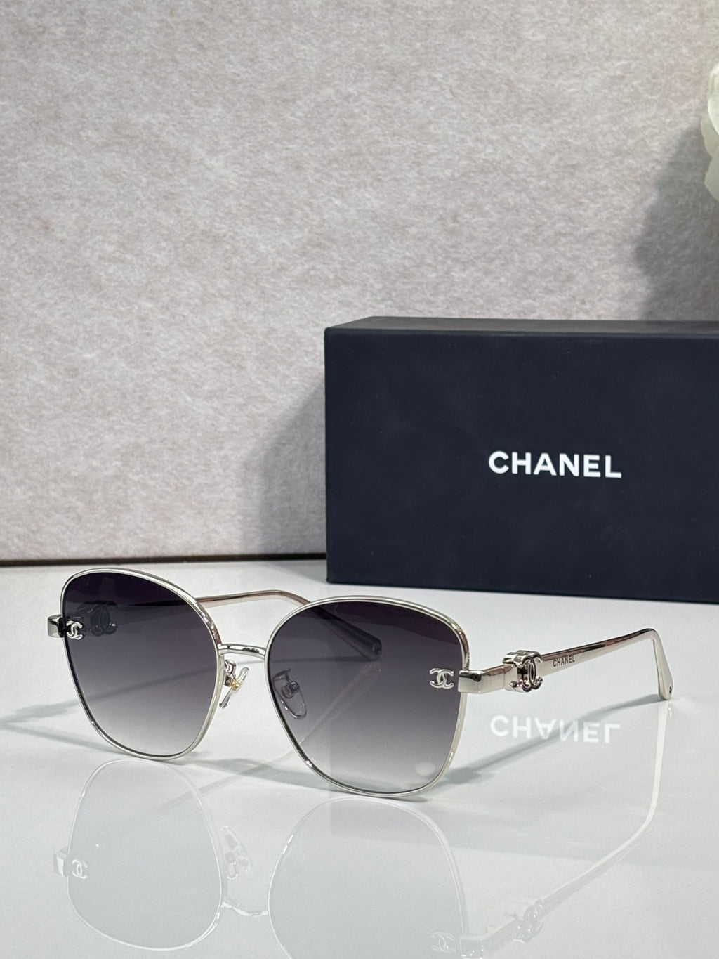 Chanel sunglasses with silver cat-eye frames and dark gray tinted lenses