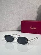Black-lens round sunglasses with gold-tone frame and sculpted hinge detail