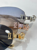 Close-up of sunglass hinges with engraved initials and mixed gold-silver hardware