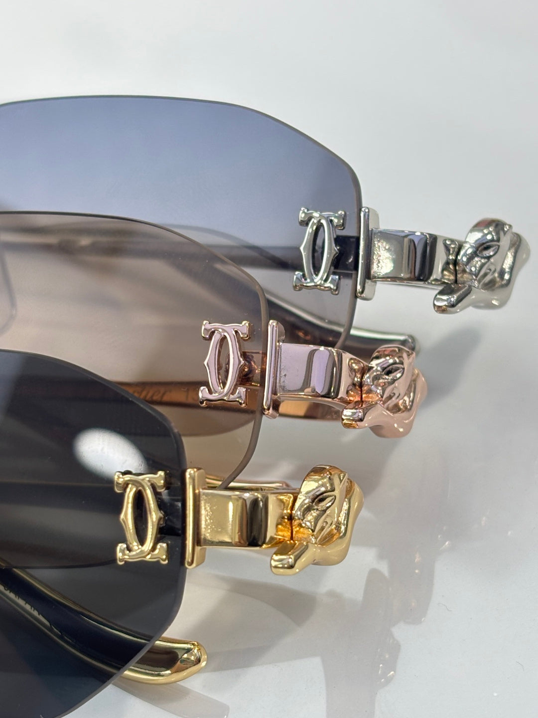 Close-up of sunglass hinges with engraved initials and mixed gold-silver hardware