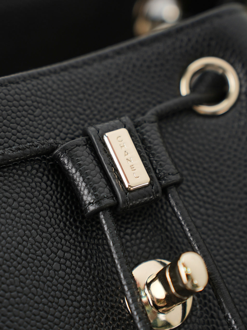 Chanel black bag clasp with gold ring, engraved metal tab, and leather strap